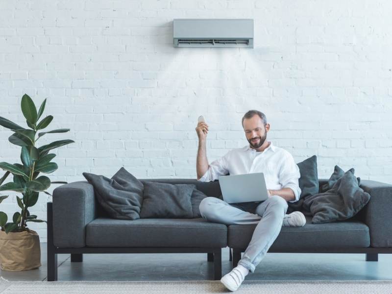 relaxed man with air conditioning system repaired